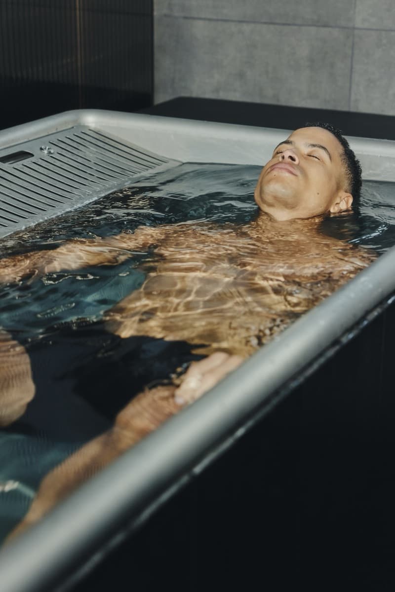 Gast liegt entspannt im kalten Wasser des Cold Plunge